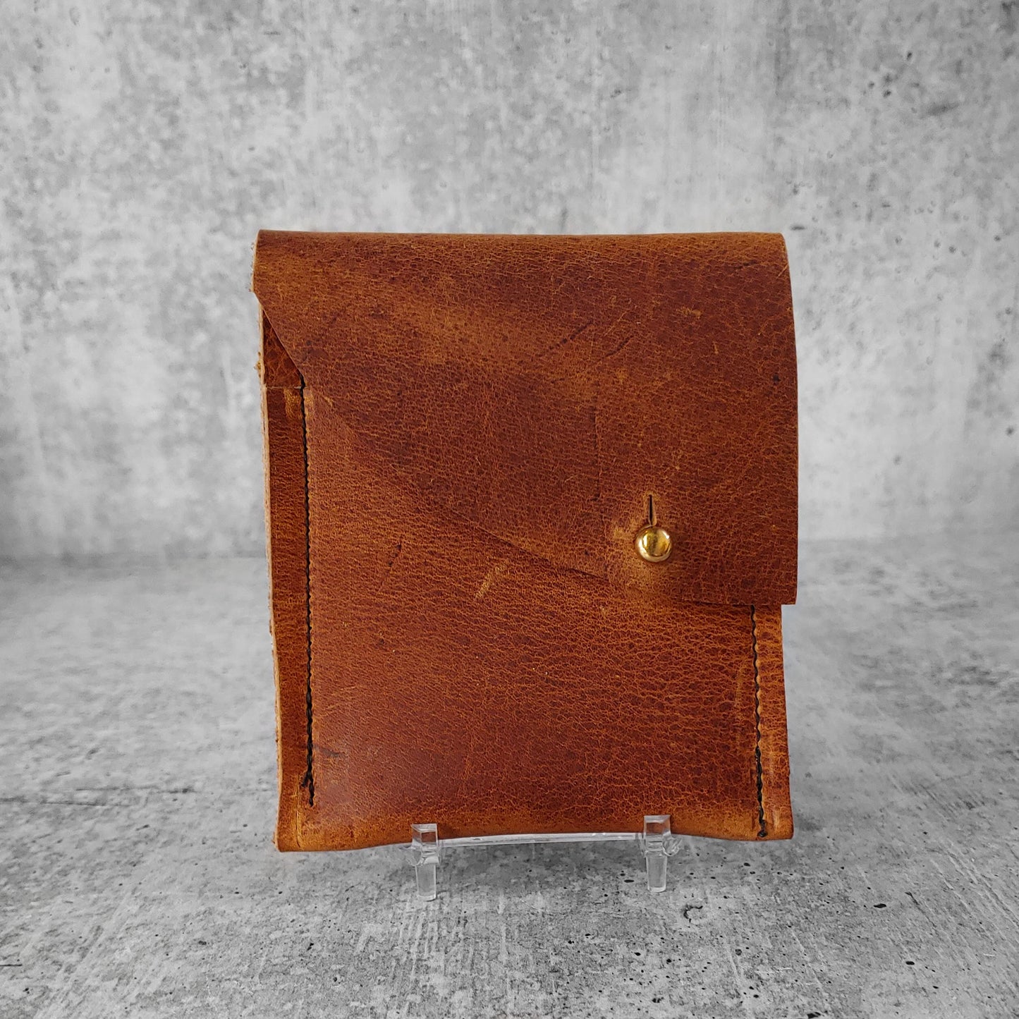 Front Facing view of "soft leather wallet right" in pecan brown against a concrete background.