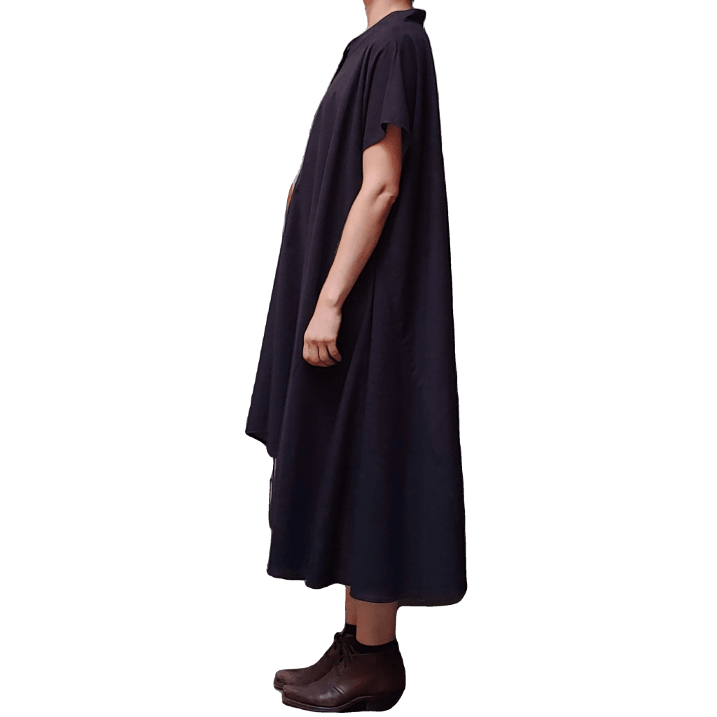 Side view of model in McCULLOUGH Geode Henley dress in black cotton at Harkensback.