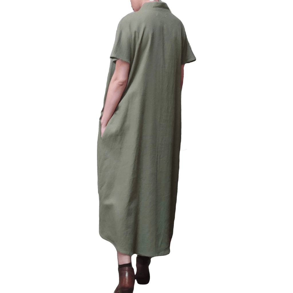 Partial back view of model in McCULLOUGH High Low Henley Tunic in olive linen at Harkensback. Hand in pocket.