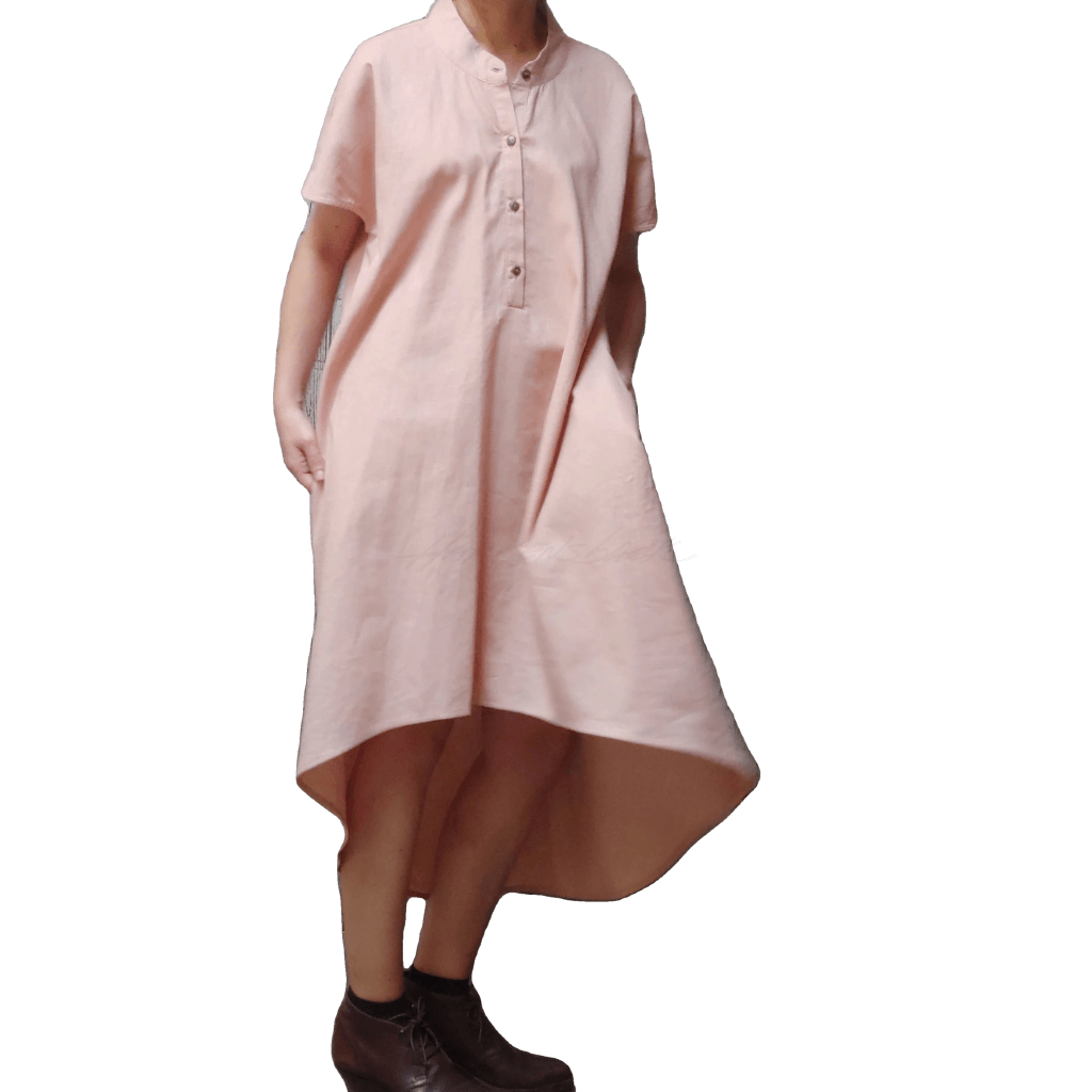 Model in McCULLOUGH High Low Henley Tunic in rose linen at Harkensback. Hem ballooning out to show fabric movement.