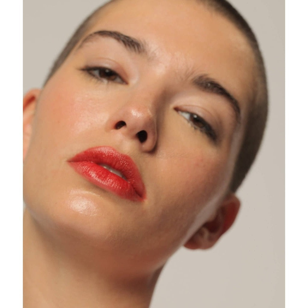 Brilliant red color NOTO Oscillate Multi-Benne Stain product showcased on fair-skinned female against cheeks and lips.