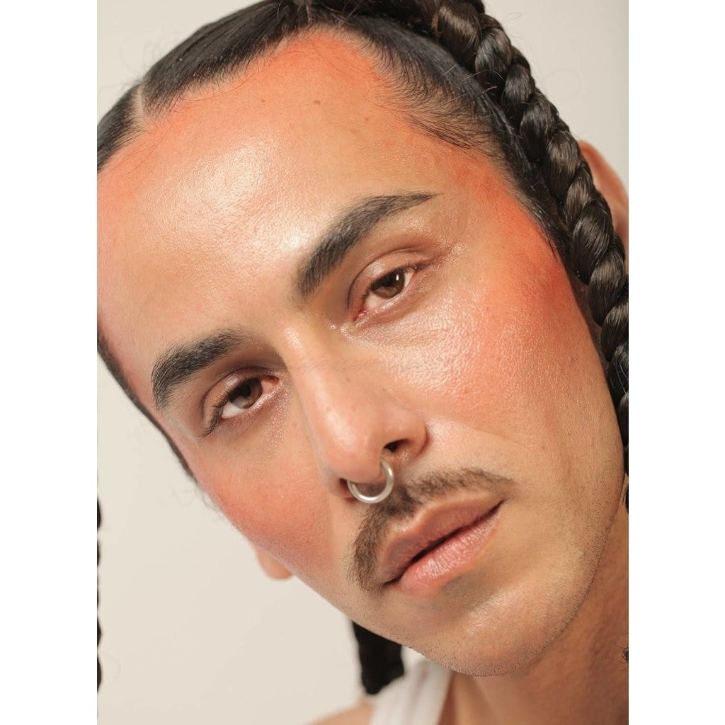Brilliant red color NOTO Oscillate Multi-Benne Stain product showcased on fair-skinned male against his cheeks and temples.