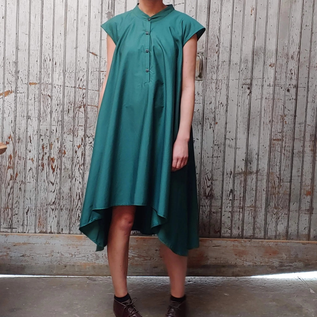 Model wearing McCULLOUGH button down Rambla swing dress in emerald poplin cotton at Harkensback. Features a nehru collar.