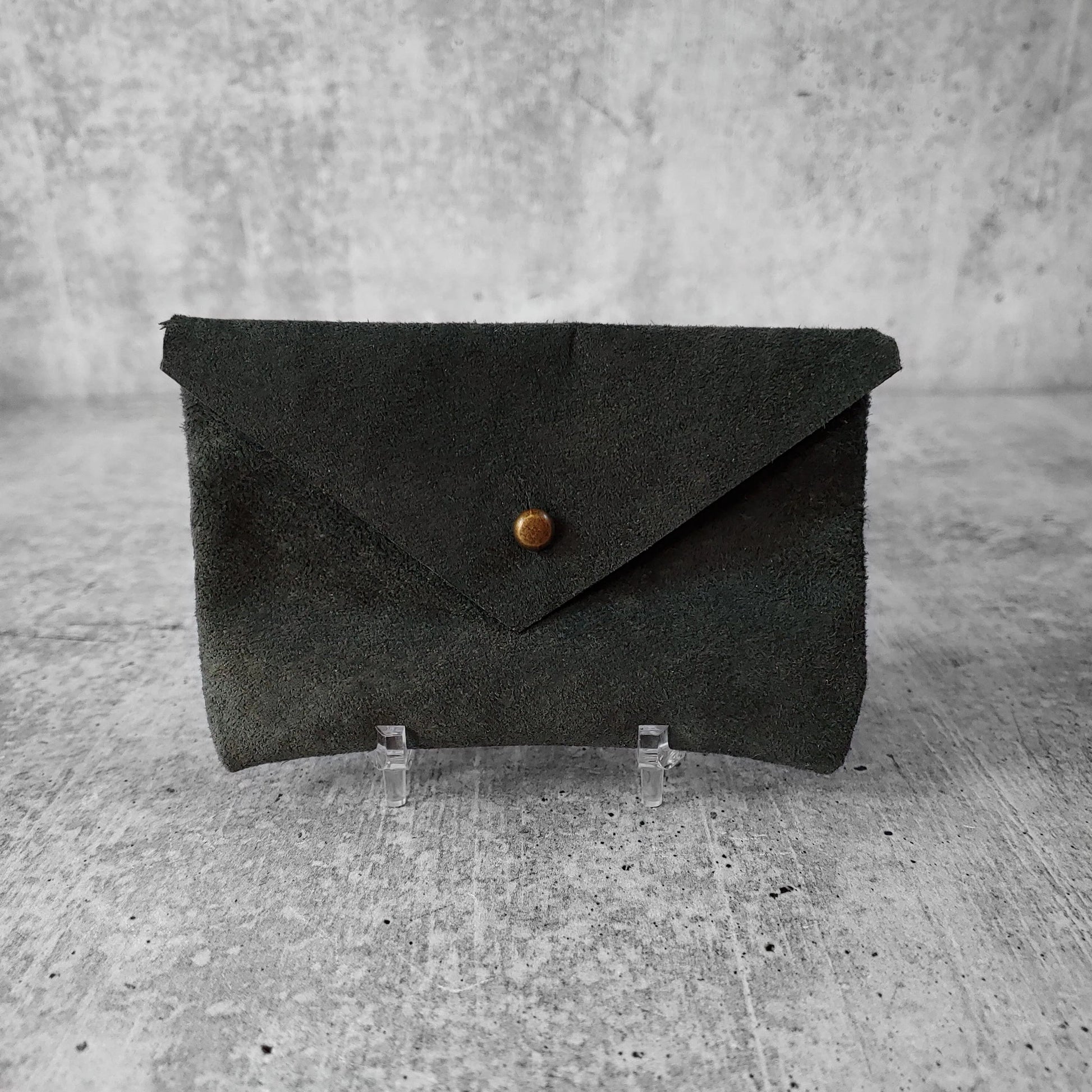 Front facing view of "soft leather card holder" in rosemary against a concrete background.