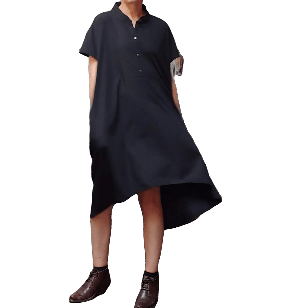 Model in McCULLOUGH button down High Low Henley Tunic in black linen at Harkensback. Dress hem ballooning out.
