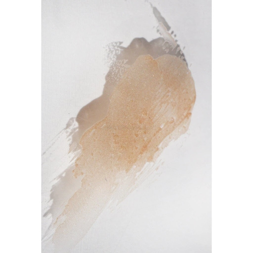 Translucent tan colored NOTO Gold Glow Stick product smudged against white surface to showcase texture and pigment.