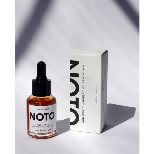 Amber colored NOTO Mini Deep Serum in glass bottle with black top displayed next to white product box with black lettering.