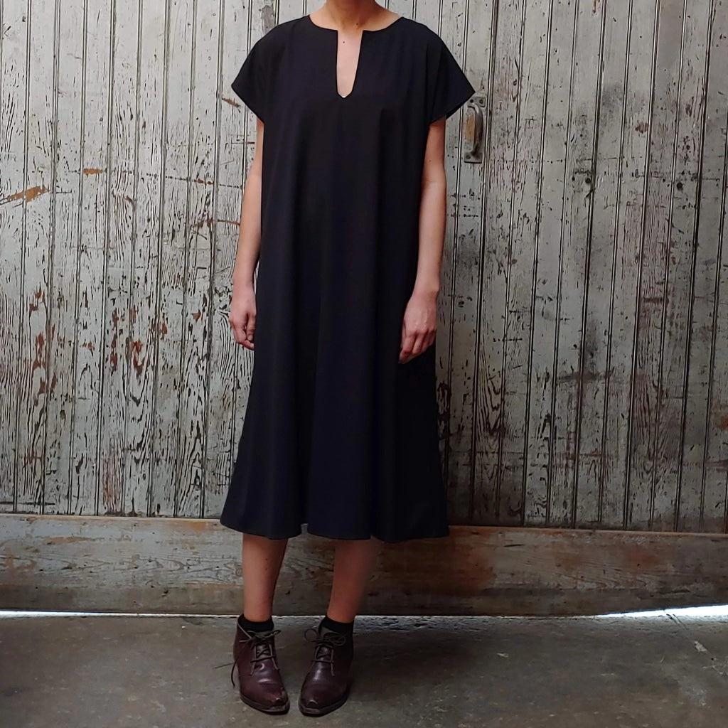 Model wearing McCULLOUGH Morian Midi swing dress in black poly rayon at Harkensback.