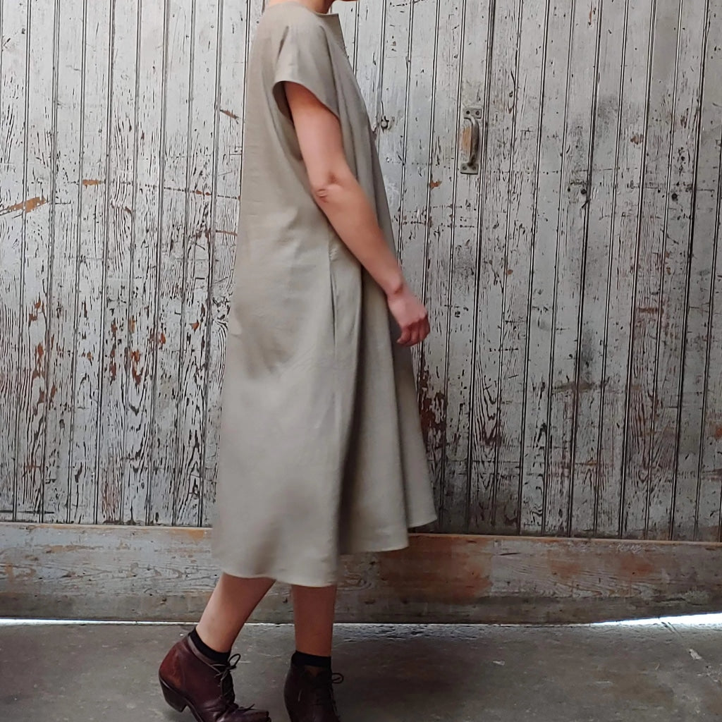 Side view of model wearing McCULLOUGH Morian Midi swing dress in moss linen at Harkensback.