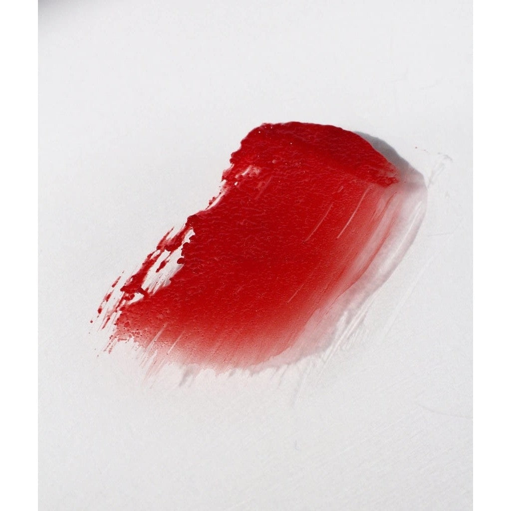 Brilliant red colored NOTO Oscillate Multi-Benne Stain product smudged against white surface to showcase texture and pigment.