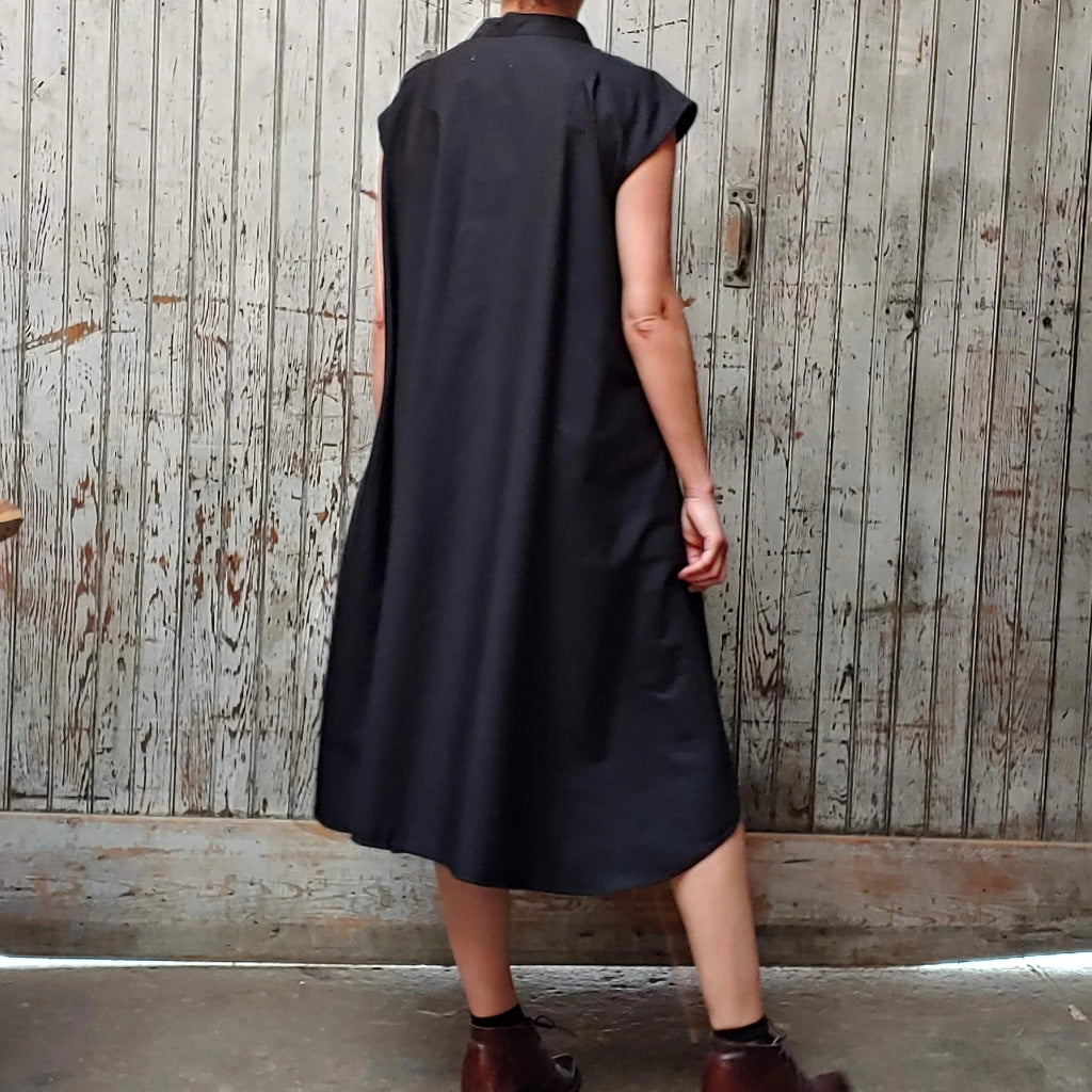 Back view of model wearing McCULLOUGH button down Rambla swing dress in black poplin cotton at Harkensback.