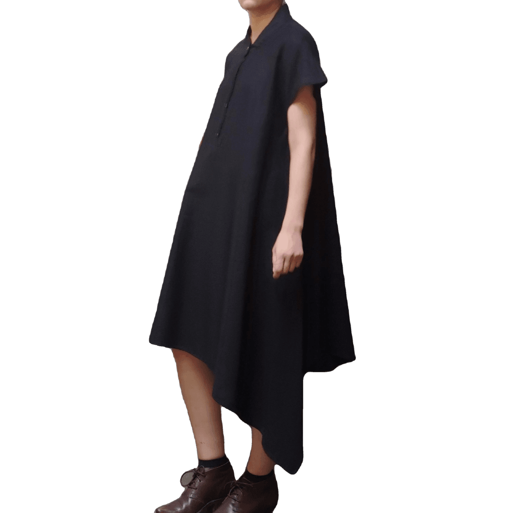 Side view of model in McCULLOUGH Short Sleeve Asymmetric Henley Tunic in black linen at Harkensback.
