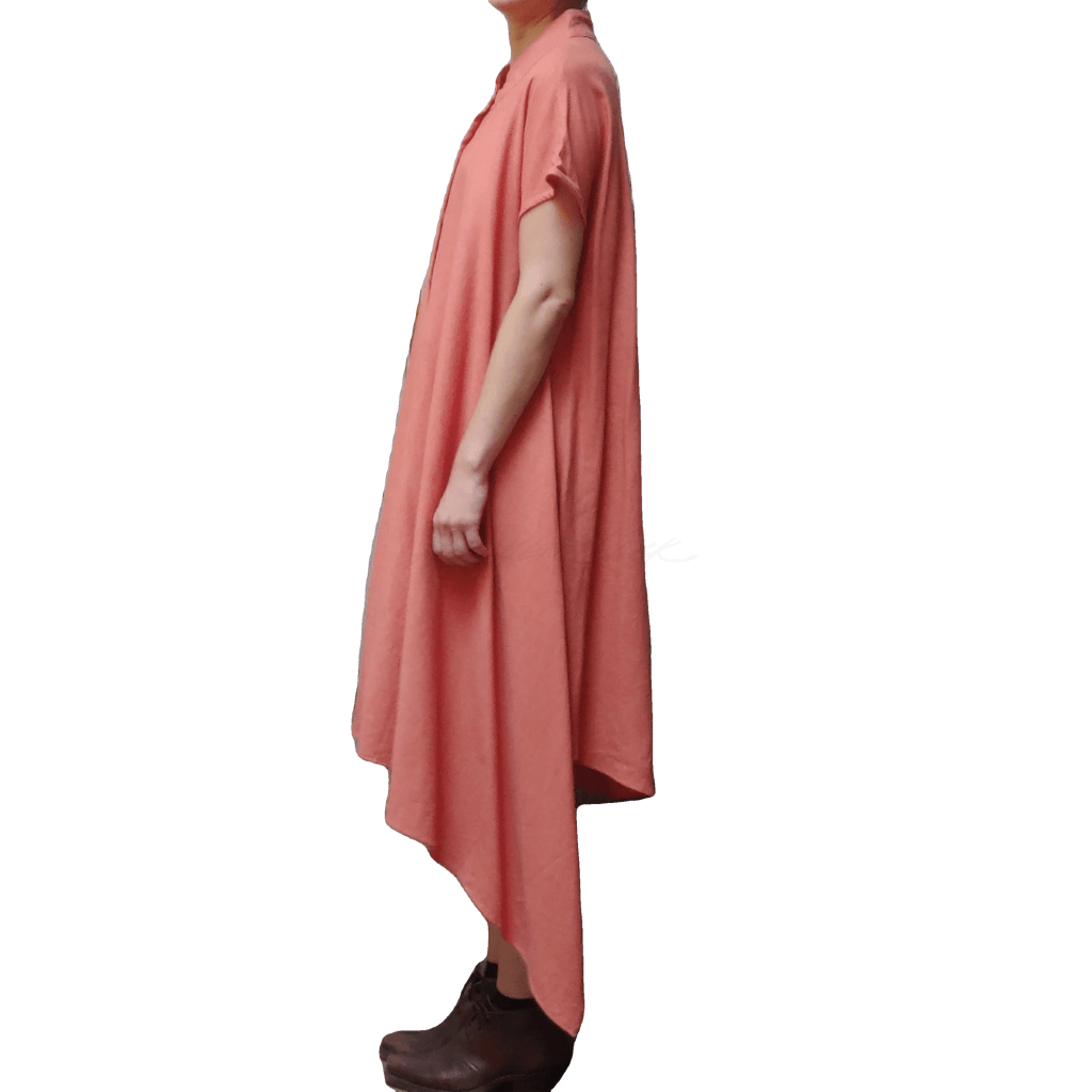 Side view of model in McCULLOUGH Short Sleeve Asymmetric Henley Tunic in coral linen at Harkensback.